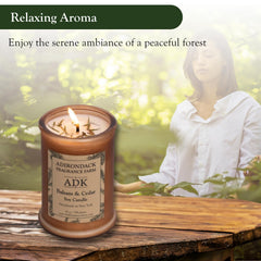 ADK Balsam & Cedar candle burning with warm forest ambiance.