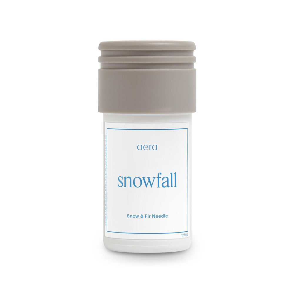 Aera Mini Snowfall bottle front view for a crisp winter scent in the living room.