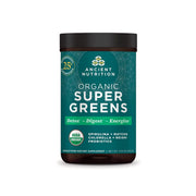 Ancient Nutrition Super Greens powder tub label visible, emphasizing organic greens blend for daily nutrition.
