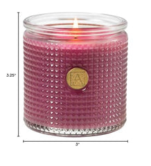 Aromatique Sparkling Currant candle in glass enhancing ambiance with floral warmth.