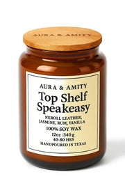 Aura & Amity Top Shelf Speakeasy candle in frosted glass enhances living room ambience.