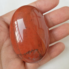 Bacatgem carnelian oval palm stone hand hold close-up showing smooth texture for focus