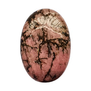 Bacatgem rhodonite oval palm stone held for meditation and calm.