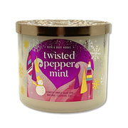 Bath & Body Works Twisted Peppermint 3-wick candle jar delivers festive fragrance in living rooms.