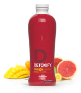 Detoxify Mega Clean Tropical bottle with pour, a refreshing detox moment.