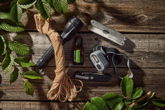 DoTERRA TerraShield Outdoor Blend on a wooden table with sunlight, signaling natural use.