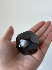 GAF TREASURES garnet polygon polished in hand highlighting size and heft