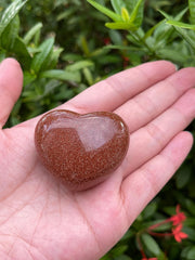 GAF Treasures Red Goldstone palm stone resting comfortably for grounding