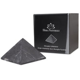 Heka Naturals unpolished shungite pyramid on desk for a calming focal point