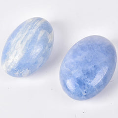 JIC Gem blue celestite palm stone resting in palm for meditation.