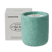 JueOne cement jar candle on a shelf enhances living room decor with elegant fragrance.