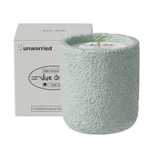 JueOne vanilla and sweet pea scented candle in a cement jar, front view, elegant ambiance.