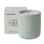 JueOne vanilla and sweet pea scented candle in a cement jar, front view, elegant ambiance.