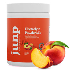 JUNP Peach flavor electrolyte mix; glass of prepared drink ready for workouts.