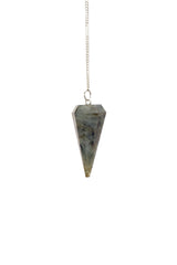 L Pedra & Crystal labrodolite pendulum in hand for divination sessions.