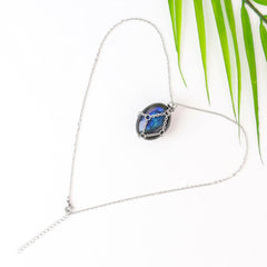 Natural crystal pendant inside the cage shows faceted shine