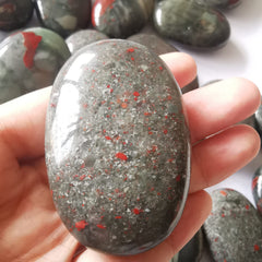 Loveliome bloodstone oval worry stone in hand for easy meditation and calm grip
