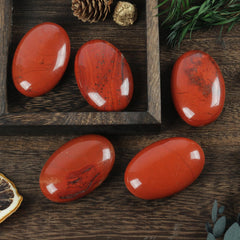 Loveliome red jasper worry stone on fountain display showing rich color.