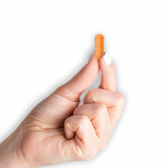 Capsules beside fresh turmeric root illustrating natural origins.