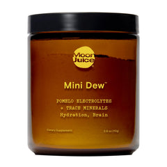 Moon Juice Mini Dew electrolytes powder being poured into a glass for instant hydration.