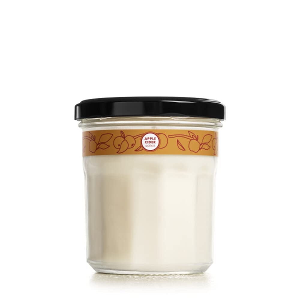 Mrs. Meyer's Apple Cider candle jar enhances cozy autumn ambiance.