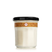 Mrs. Meyer's Apple Cider candle jar enhances cozy autumn ambiance.