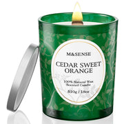 M&SENSE Cedarwood Orange candle jar close-up with warm amber glow.