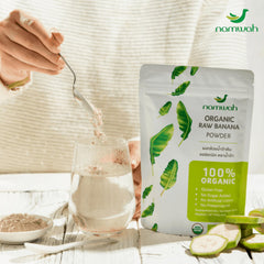 Namwah Green Banana Powder poured into warm water for dissolving and drinking.
