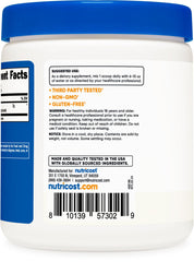 Nutricost Arginine AKG powder being poured into a glass for mixing.