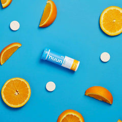 Nuun Sport Orange tablets dissolving in water to create a refreshing orange drink.