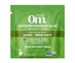 Steaming OM Mushroom Superfood Matcha Latte Blend cup showing creamy texture.