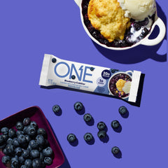 ONE Blueberry Cobbler bar held outdoors for an on-the-go snack