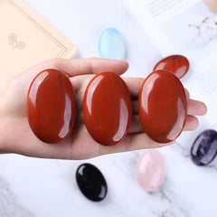 QINJIEJIE Red Jasper palm stone close-up reveals natural color variations.