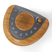 Raynic Noise Machine with a warm wood-grain finish for a cozy sleep setup.