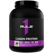 Rule 1 Proteins Casein scoop beside a glass for nighttime fueling