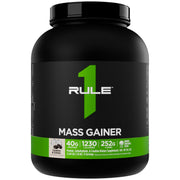 Rule1 Mass Gainer being poured into a shaker for a calorie-dense shake.