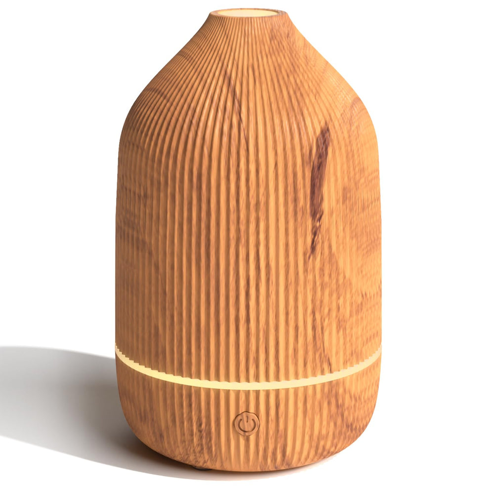 Salubrito essential oil diffuser with wood grain on desk delivers subtle ambient aroma.