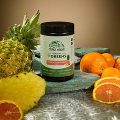 Terra Origin Healthy Greens scoop beside the jar, ready for a smooth energy support shake