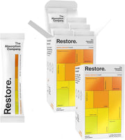 The Absorption Company electrolyte packets dissolving in mango lemonade for post-workout hydration