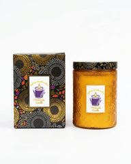ThinkLabs Organic Daisy Cedar Candle in amber glass jar creates a cozy ambiance.