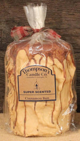 Thompson's Candle Co Super Scented LG Cinnamon Bun pillar candle glowing with warm aroma