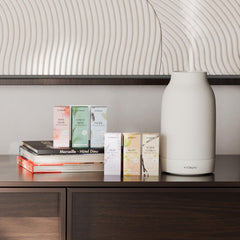 Vitruvi Sleep Scent Refill packaging on nightstand in a cozy bedroom setting.