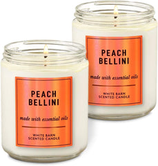 White Barn Peach Bellini candle 7 oz glowing warmly, delivering a relaxing aroma.