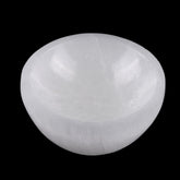 Wish Well selenite bowl on a bedside table cleanses crystals' energy overnight