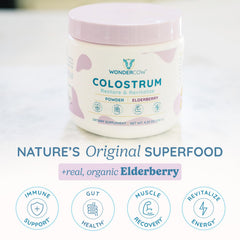 WonderCow elderberry-infused colostrum powder poured into smoothie for immune support.