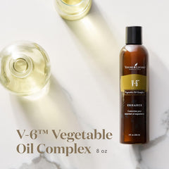 Pouring Young Living V-6 Enhanced oil for massage and blends.