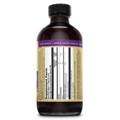 Pouring ZAND Honey Gardens Elderberry Syrup shows smooth consistency and deep hue.