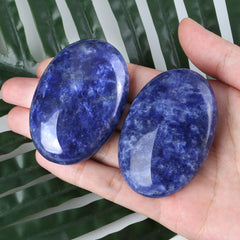 Zhiyuxi blue sodalite palm stone held in hand for stress relief.