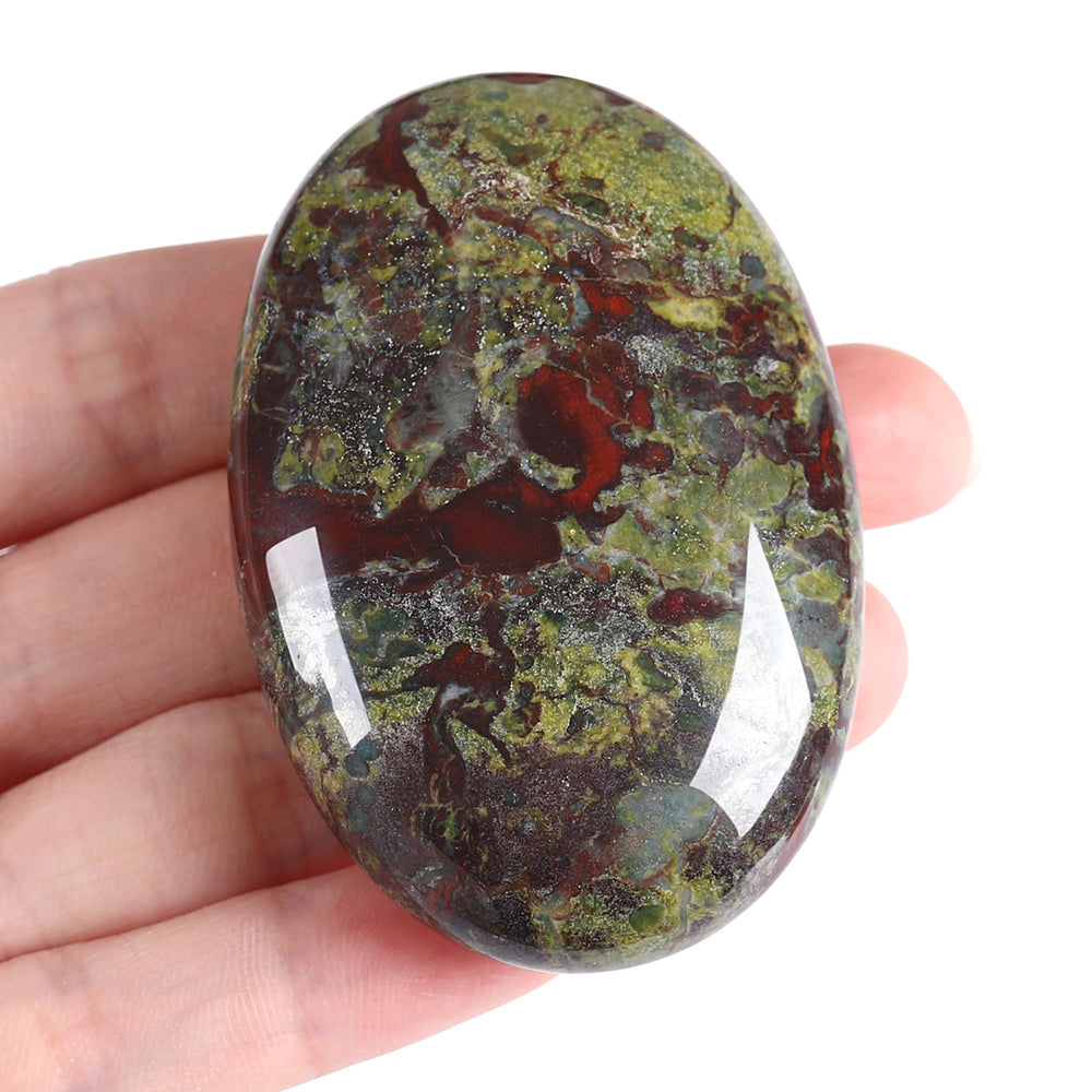 Zhiyuxi dragon blood oval palm stone held for calming energy balance.