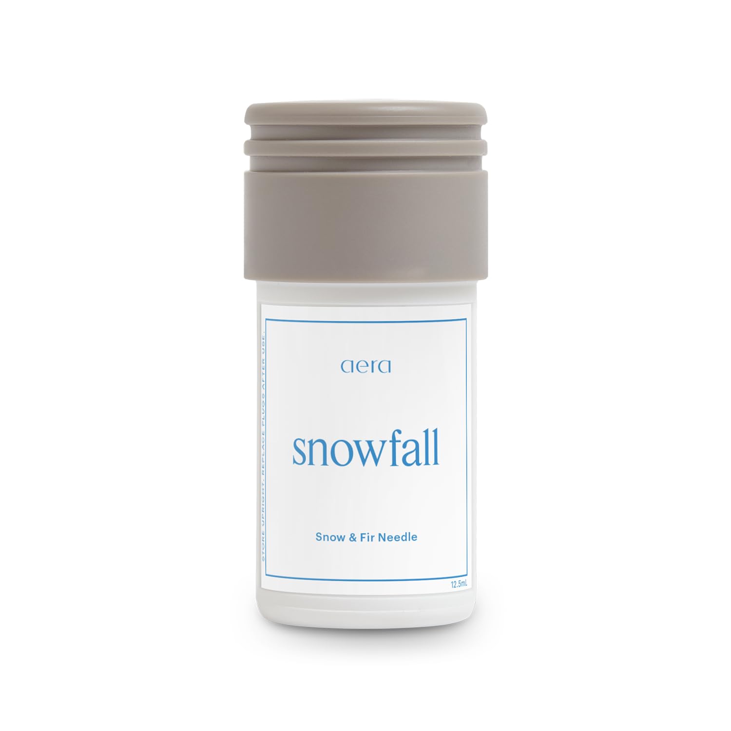 Aera Mini Snowfall bottle front view for a crisp winter scent in the living room.
